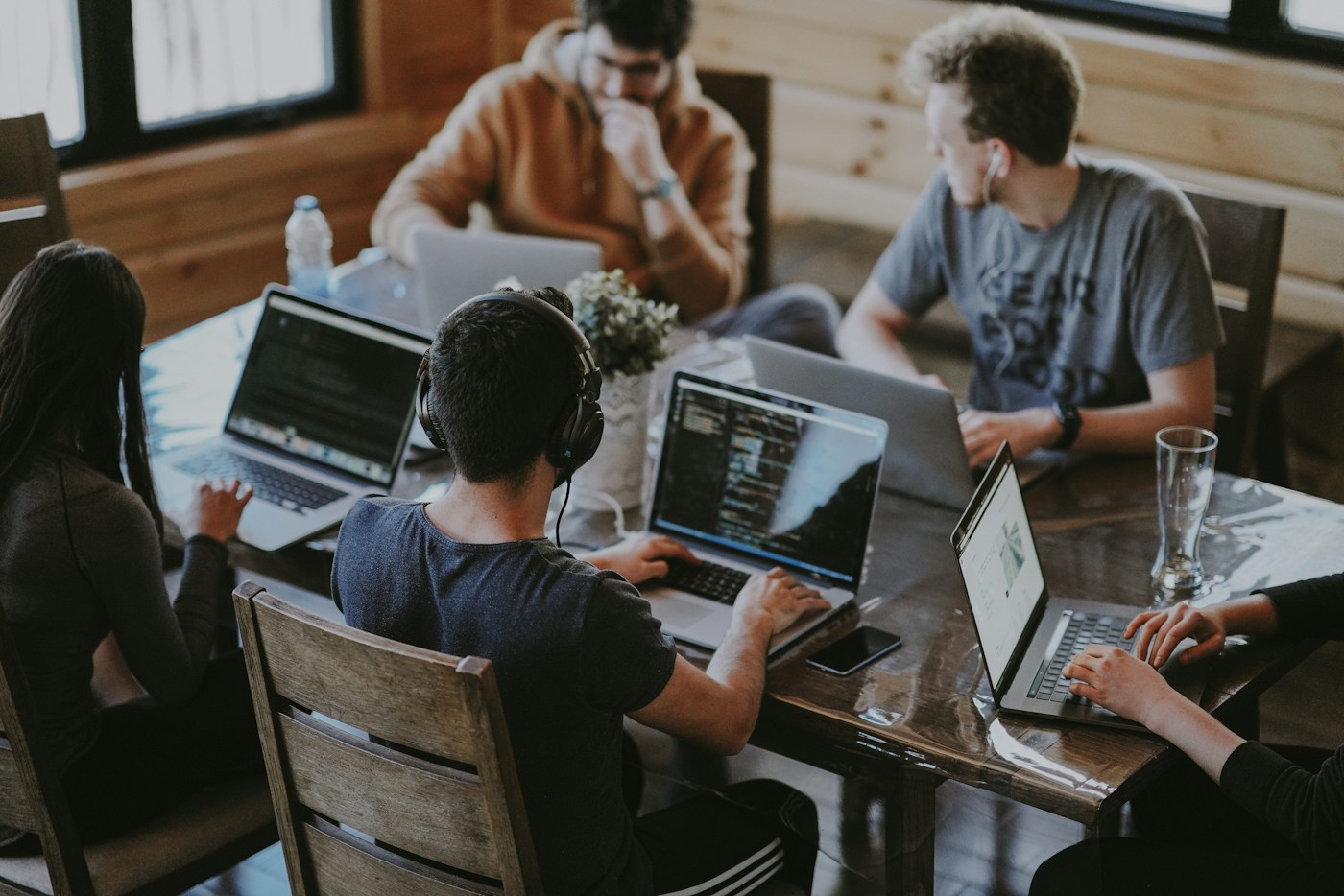 Illustrative photograph of a group collaborating around laptops